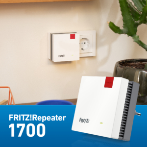 Ein FRITZ!Repeater 1700 ist in einer Wandsteckdose in einem modernen Raum mit einer Pflanze, einem Keramiktopf und anderen Haushaltsgegenständen eingesteckt. Der Produktname erscheint auf einem blauen Banner am unteren Rand und hebt die nahtlose Mesh-WLAN-Konnektivität hervor.