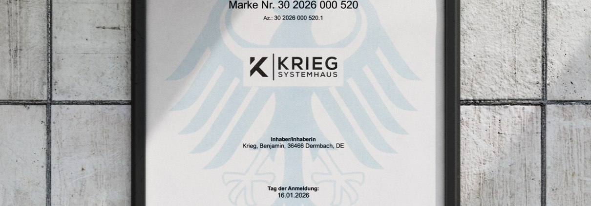 Eine gerahmte deutsche Urkunde mit dem Titel „Urkunde“, die ein schwarzes Adlerwappen und das Logo von KRIEG SYSTEMHAUS trägt und an einer hellen Wand hängt.